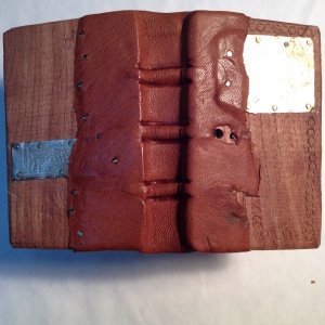 Mesquite wood boards, leather and nickel-silver metal patches. Measures 2.5" x 4" fits into back pocket easily.